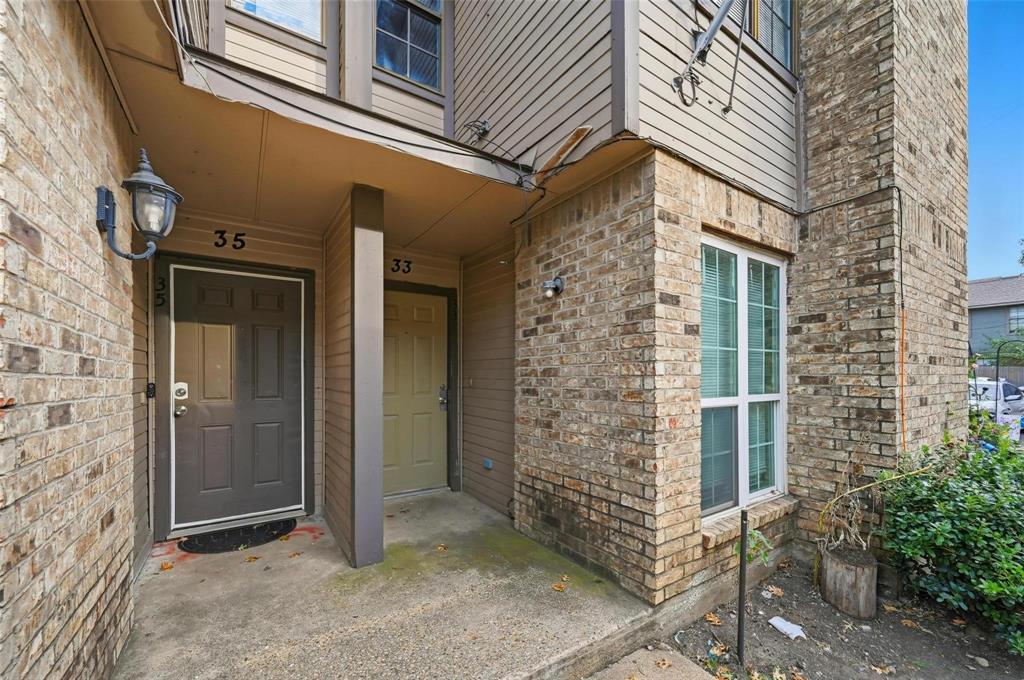 8001 Rothington Road, Unit 3137 Dallas, TX 75227 - Photo 8 of 21 Brick exterior featuring an entry door with an overhead light fixture, a sidelight window, and a concrete landing