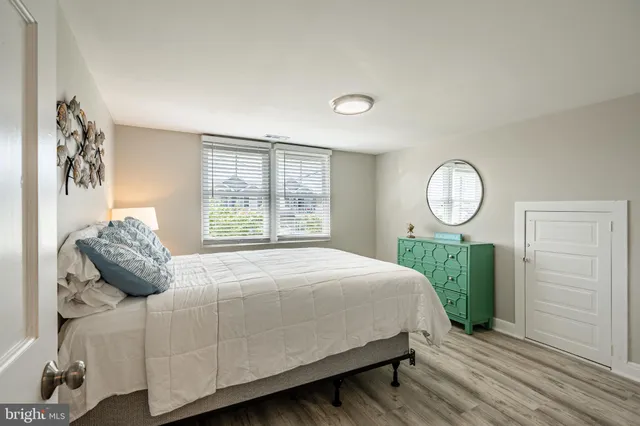 a bedroom with a bed mirror and a window