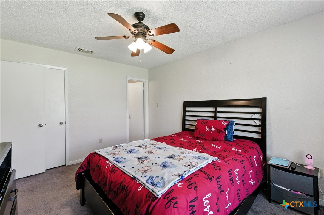 127 Jordan Loop Nolanville, TX 76559 - Photo 14 of 18 a bedroom with a bed and a chandelier