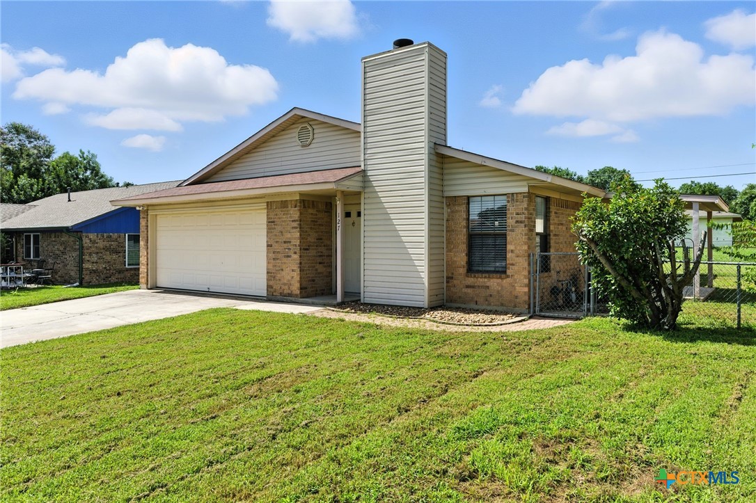 127 Jordan Loop Nolanville, TX 76559 - Photo 2 of 18 a front view of a house with a yard and garage
