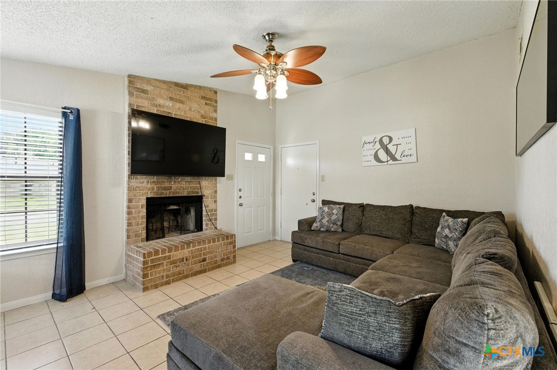 127 Jordan Loop Nolanville, TX 76559 - Photo 5 of 18 a living room with furniture a flat screen tv and a fireplace