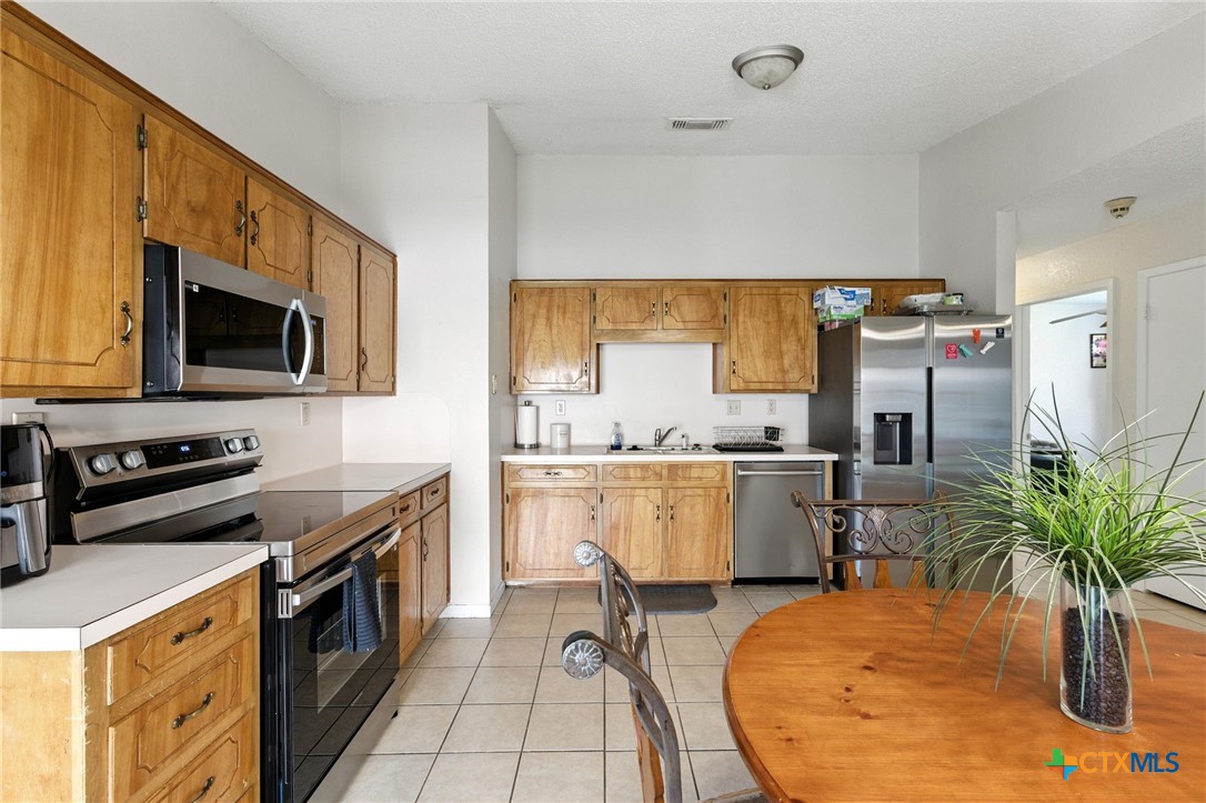 127 Jordan Loop Nolanville, TX 76559 - Photo 6 of 18 a kitchen with sink a microwave and refrigerator