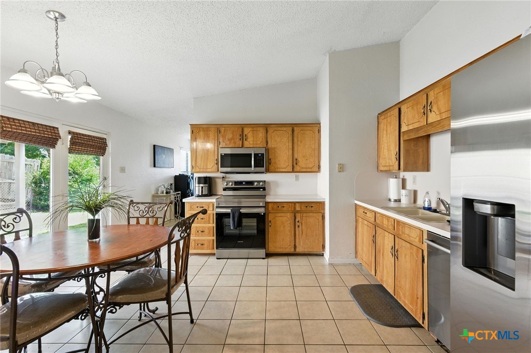 127 Jordan Loop Nolanville, TX 76559 - Photo 7 of 18 a kitchen with stainless steel appliances a dining table chairs stove and sink