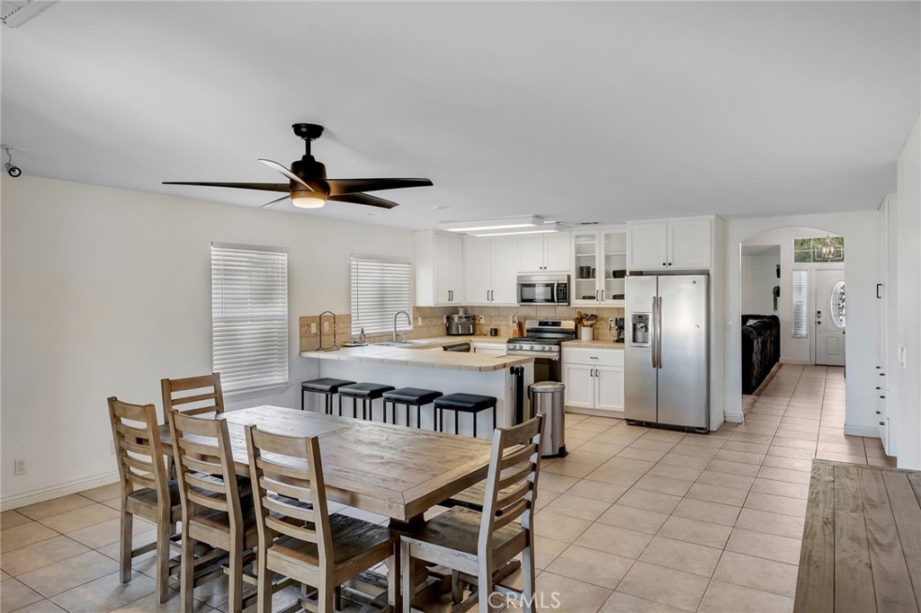 14952 Rivers Edge Road Helendale, CA 92342 - Photo 17 of 33 a kitchen with refrigerator cabinets dining table and chairs