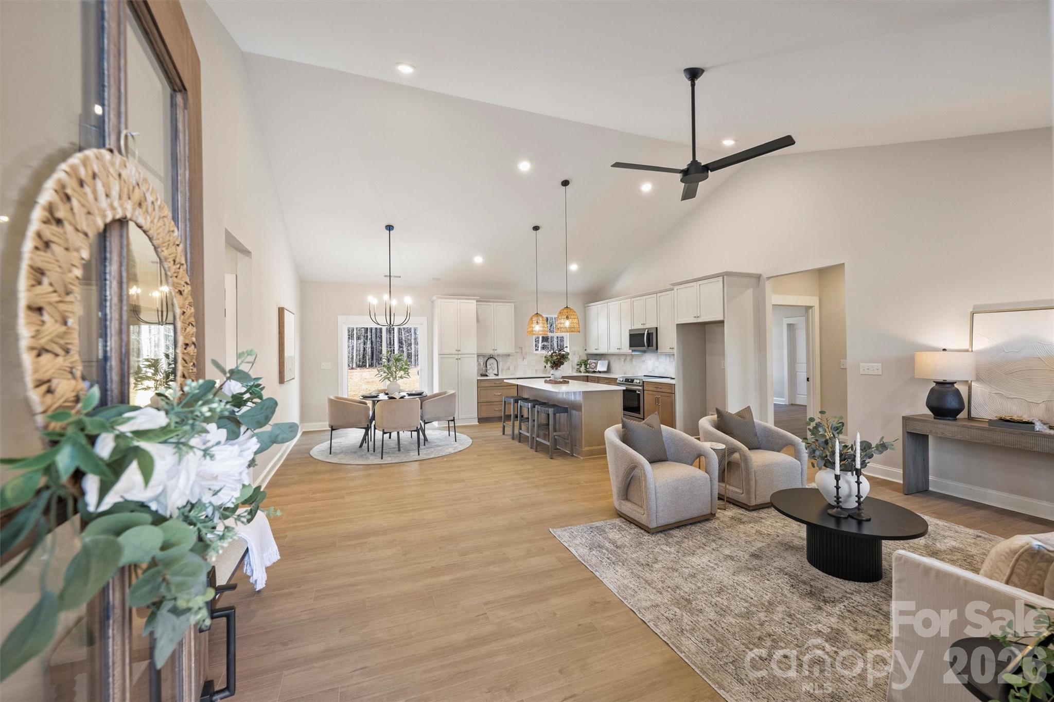 a living room with furniture a chandelier and a dining table