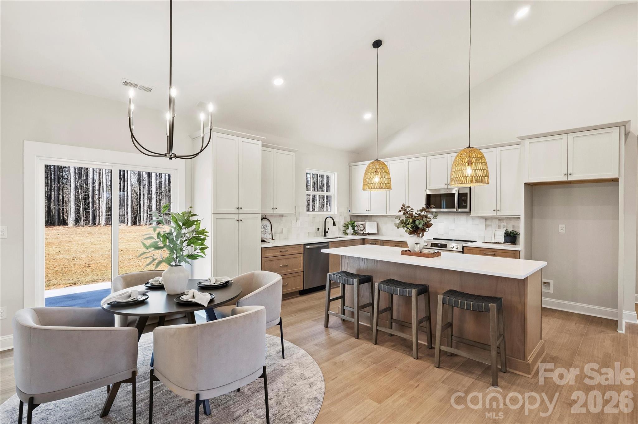 2307 Lee Lawing Road Lincolnton, NC 28092 - Photo 18 of 42 a kitchen island with stainless steel appliances a stove a sink a window and chairs