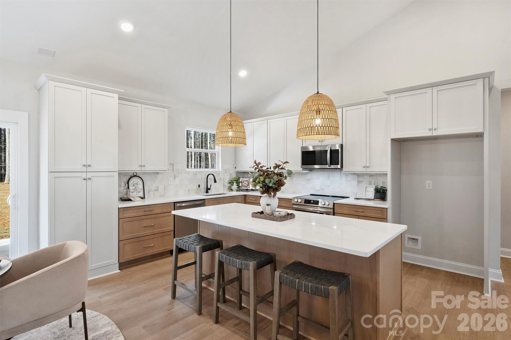 2307 Lee Lawing Road Lincolnton, NC 28092 - Photo 20 of 42 a kitchen with kitchen island a dining table chairs and white cabinets