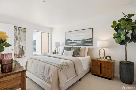 a bedroom with a bed and a night stand next to a window