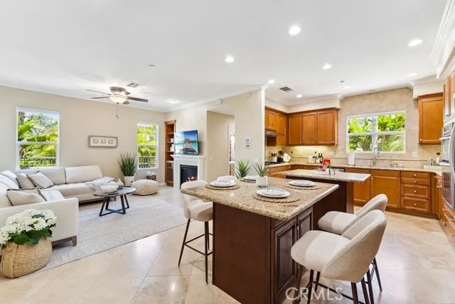 a living room with furniture kitchen view and a large window