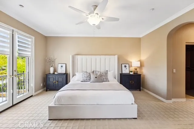 a bedroom with a large bed and a chandelier