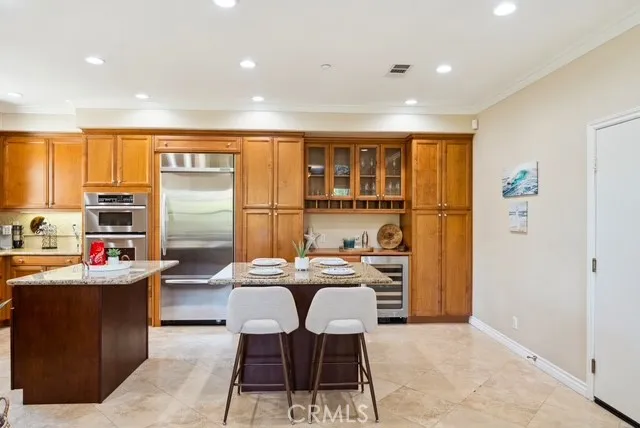 a kitchen with stainless steel appliances kitchen island granite countertop a refrigerator and a stove top oven