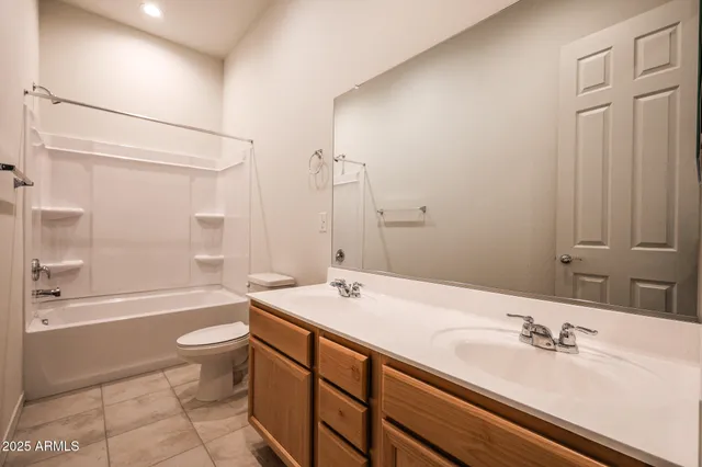 a bathroom with a bathtub shower sink vanity and toilet