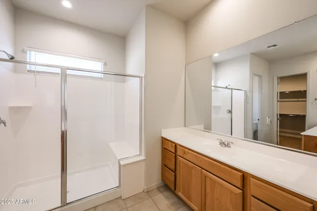a bathroom with a double vanity sink mirror and shower
