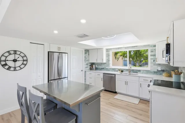 a kitchen with a table chairs sink and cabinets