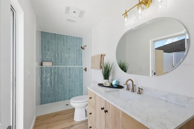 a bathroom with a granite countertop sink toilet and shower