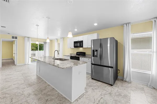 a view of a kitchen with a refrigerator and a stove top oven
