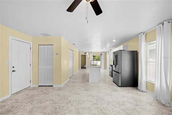 a kitchen with stainless steel appliances granite countertop a refrigerator a sink a stove a microwave and a refrigerator