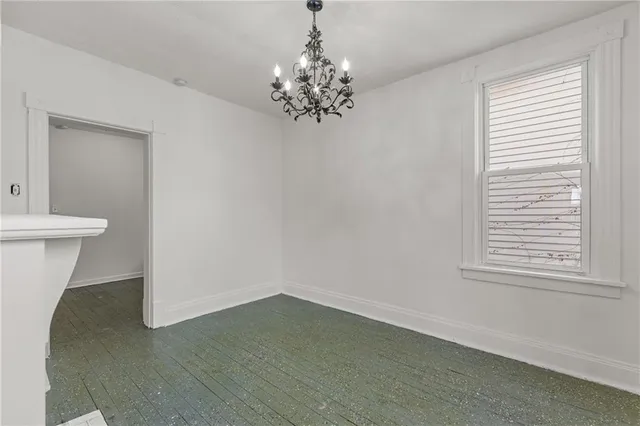 a view of wooden floor in an empty room with a window