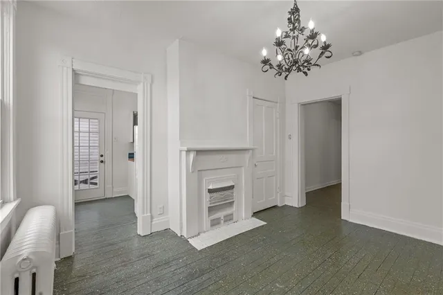 wooden floor in an empty room with a chandelier