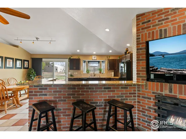 a living room with stainless steel appliances furniture and a kitchen view