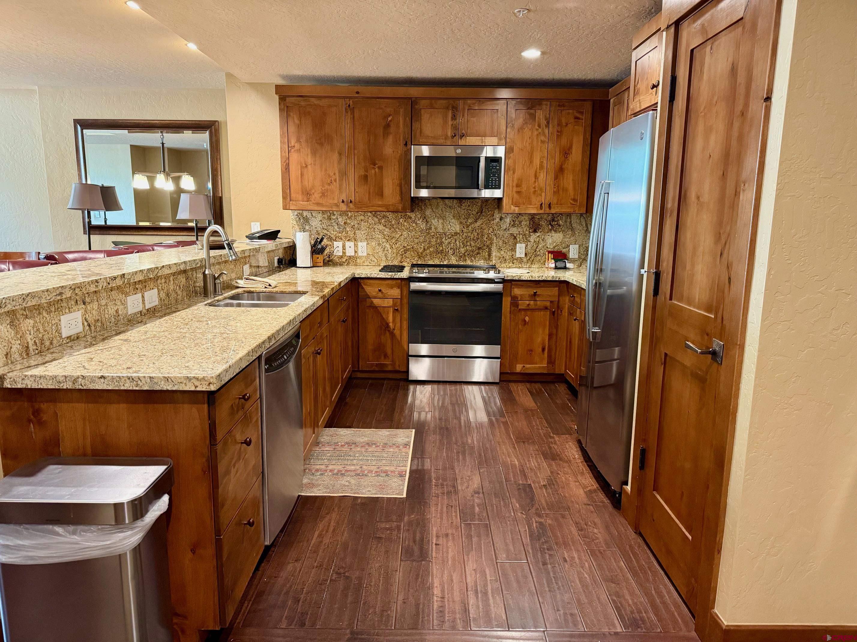 24 Sheol Street, Unit 506 Durango, CO 81301 - Photo 5 of 45 a kitchen with stainless steel appliances granite countertop a kitchen island a stove a sink and a refrigerator