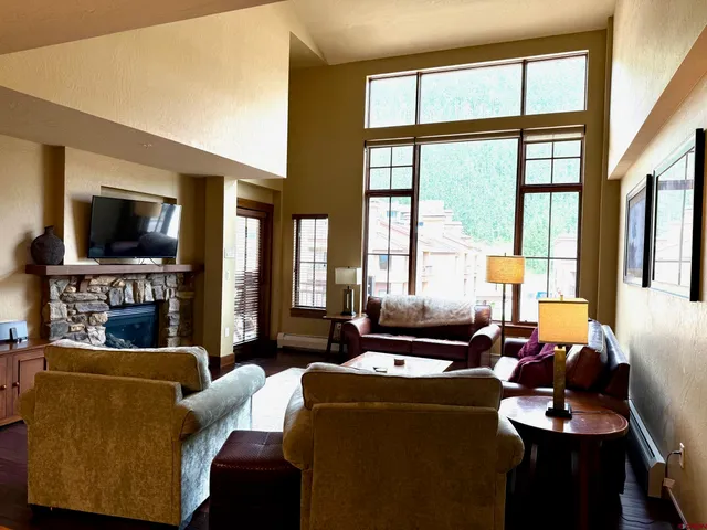 a living room with furniture a large window and a flat screen tv