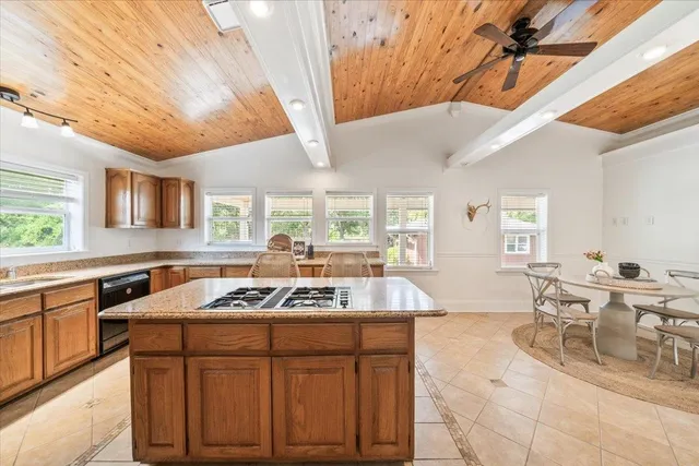 a kitchen with stainless steel appliances granite countertop a sink a stove cabinets counter space and windows