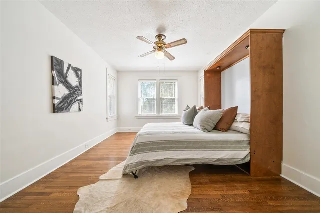 a bedroom with a bed wooden floor and window