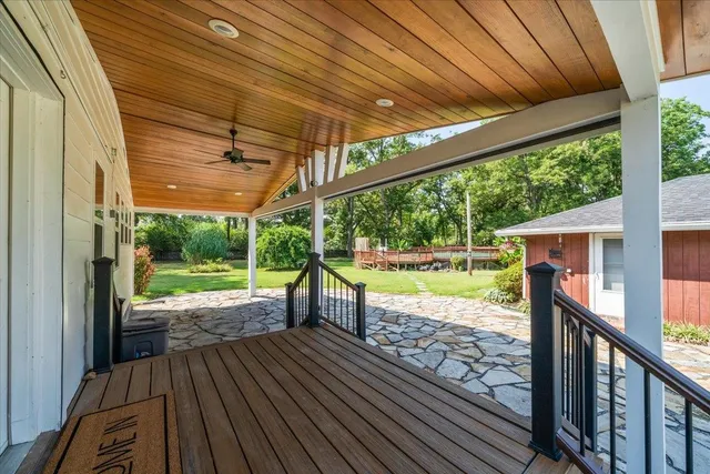 a view of a deck with wooden floor next to a yard