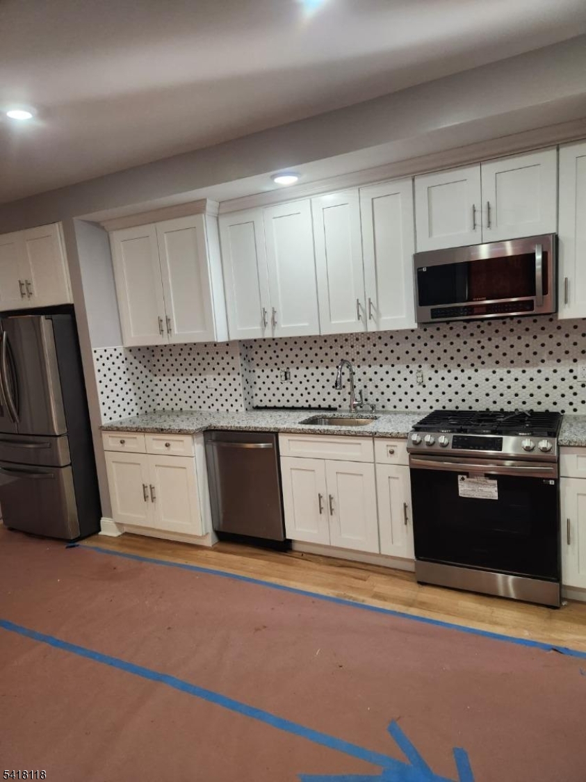 464 Walnut Street Elizabeth, NJ 07201 - Photo 9 of 22 a kitchen with stainless steel appliances granite countertop a stove a sink and a microwave