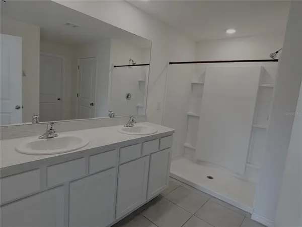 a bathroom with a shower sink vanity and mirror