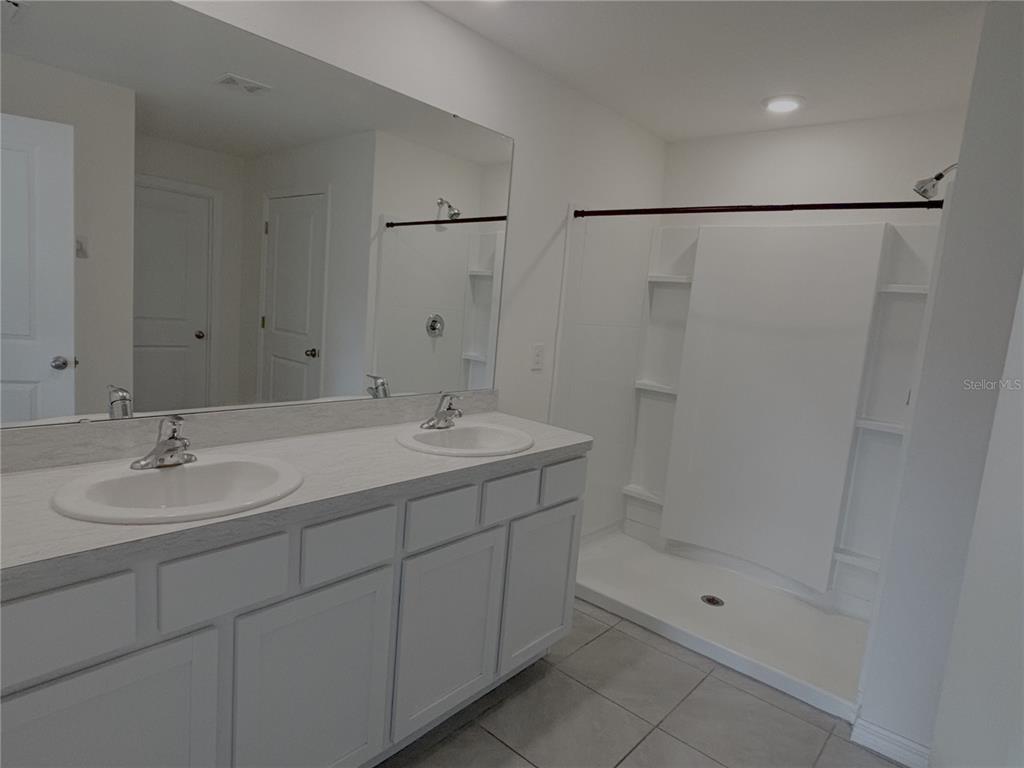 8940 Southwest 50th Terrace Ocala, FL 34476 - Photo 7 of 21 a bathroom with a shower sink vanity and mirror