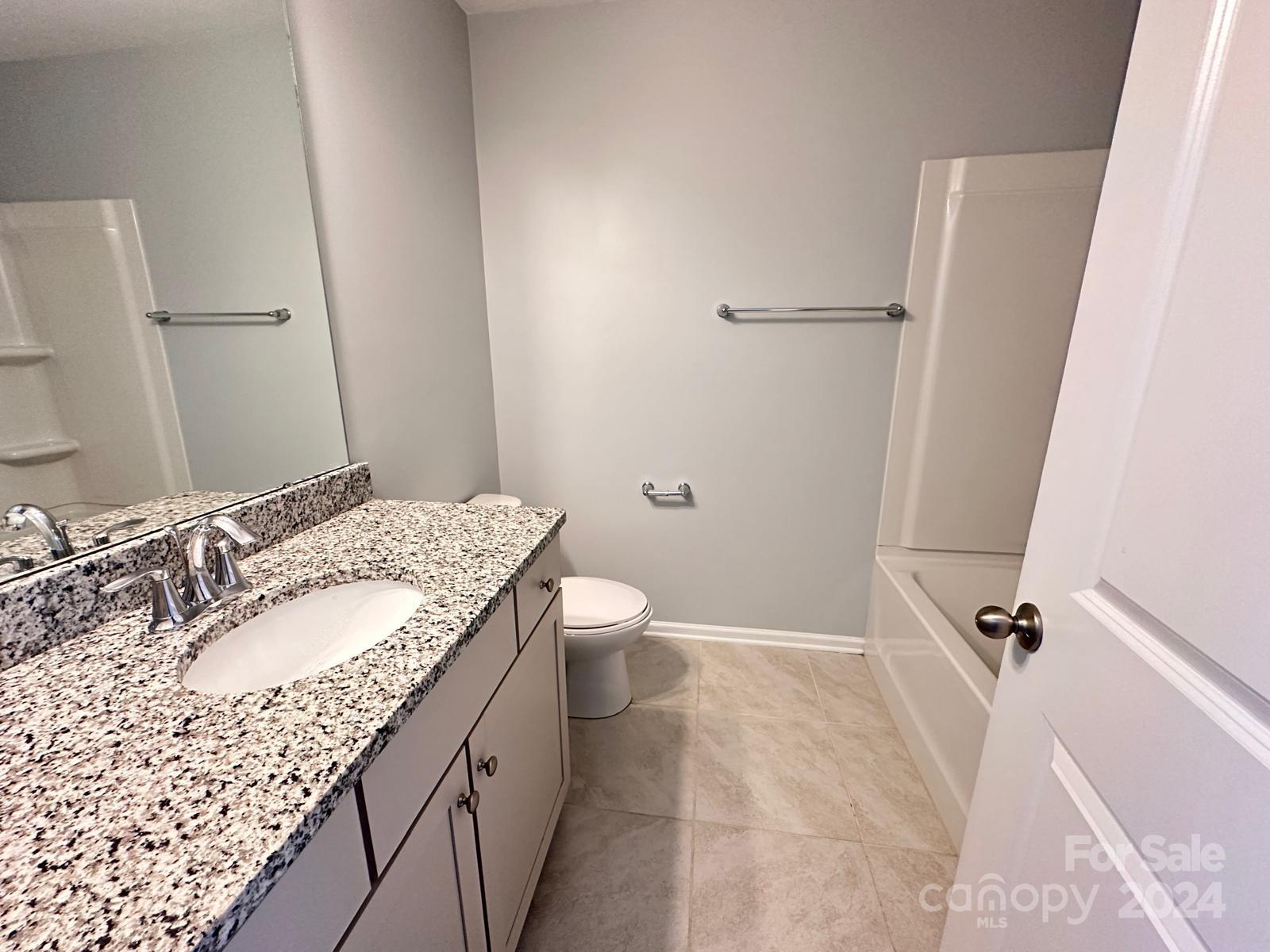 7040 Harris Bay Road Charlotte, NC 28269 - Photo 18 of 27 a bathroom with a granite countertop sink a toilet and shower