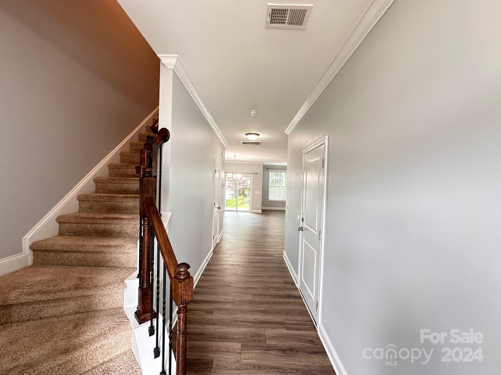 7040 Harris Bay Road Charlotte, NC 28269 - Photo 4 of 27 a view of a hallway with wooden floor and staircase