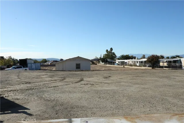 a view of dirt road with a building in the background