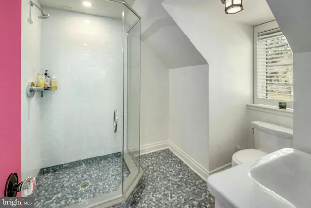 a bathroom with a granite countertop sink a mirror and shower