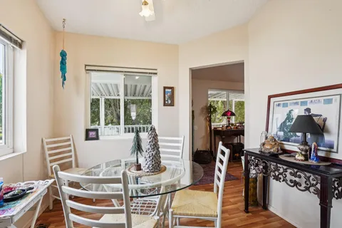 a living room with furniture a flat screen tv and a dining table