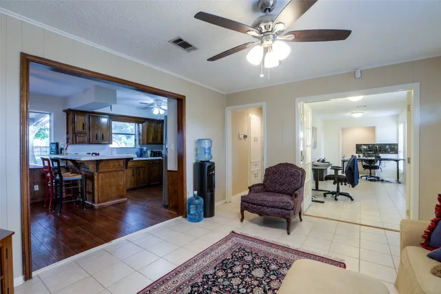 a living room with furniture and a dining table with wooden floor