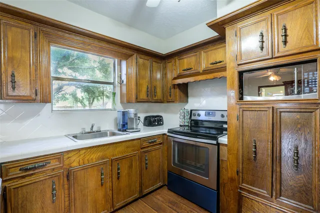 a kitchen with stainless steel appliances granite countertop a refrigerator a sink dishwasher a stove and white countertops with cabinets