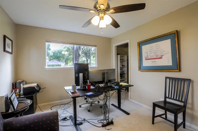 a view of a workspace with furniture and a window