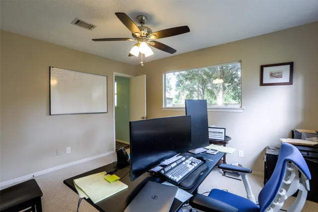 a desktop computer sitting on top of a desk with chair and wooden floor