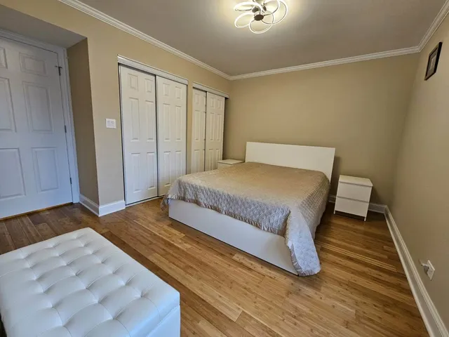 a bedroom with a bed and wooden floor