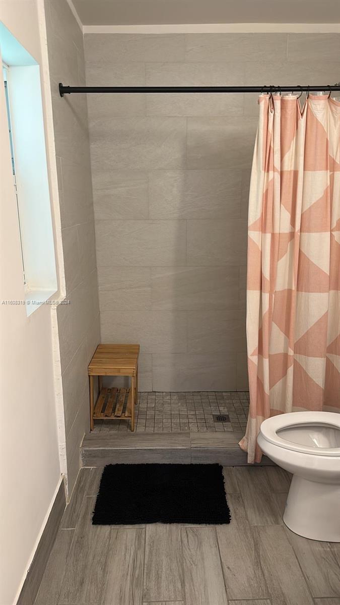 671 Northwest 50th Street, Unit 2 Miami, FL 33127 - Photo 11 of 14 a bathroom with a sink a toilet a mirror and shower