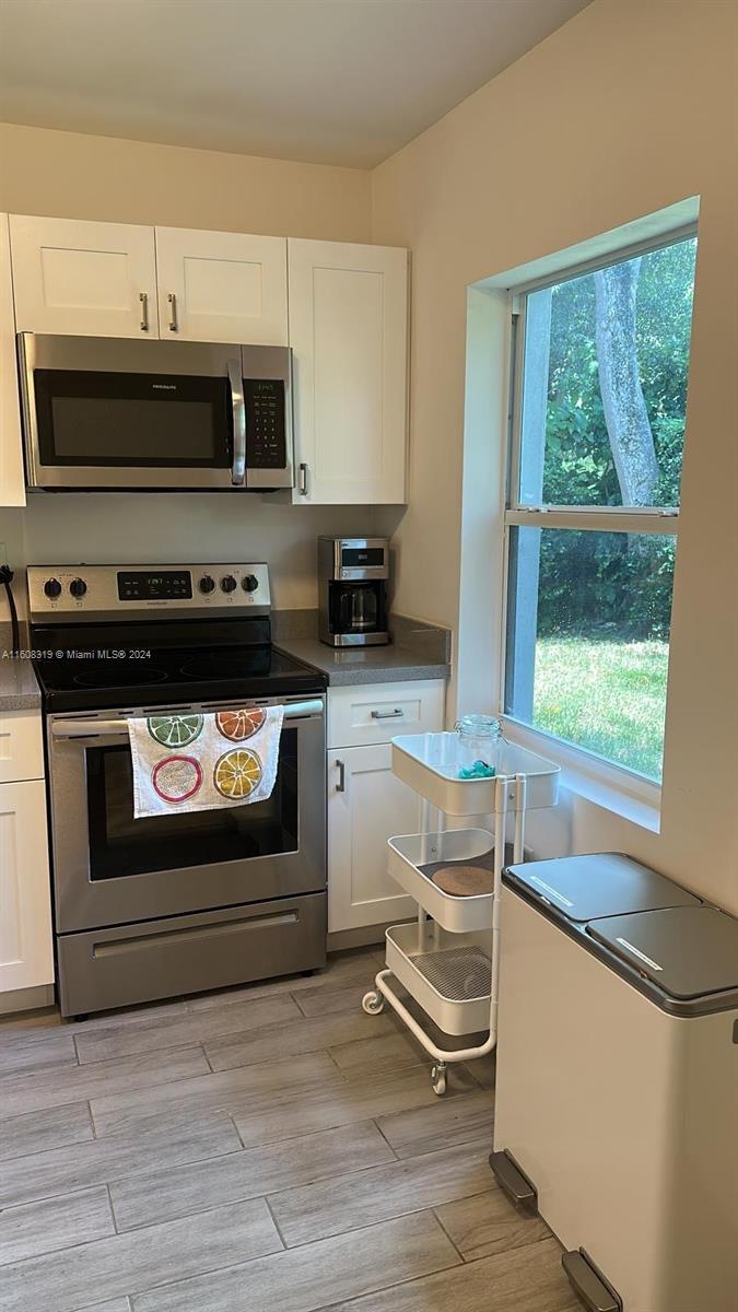 671 Northwest 50th Street, Unit 2 Miami, FL 33127 - Photo 4 of 14 a kitchen with a stove and a microwave