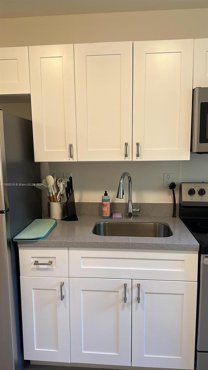 671 Northwest 50th Street, Unit 2 Miami, FL 33127 - Photo 6 of 14 a kitchen with appliances cabinets and a sink