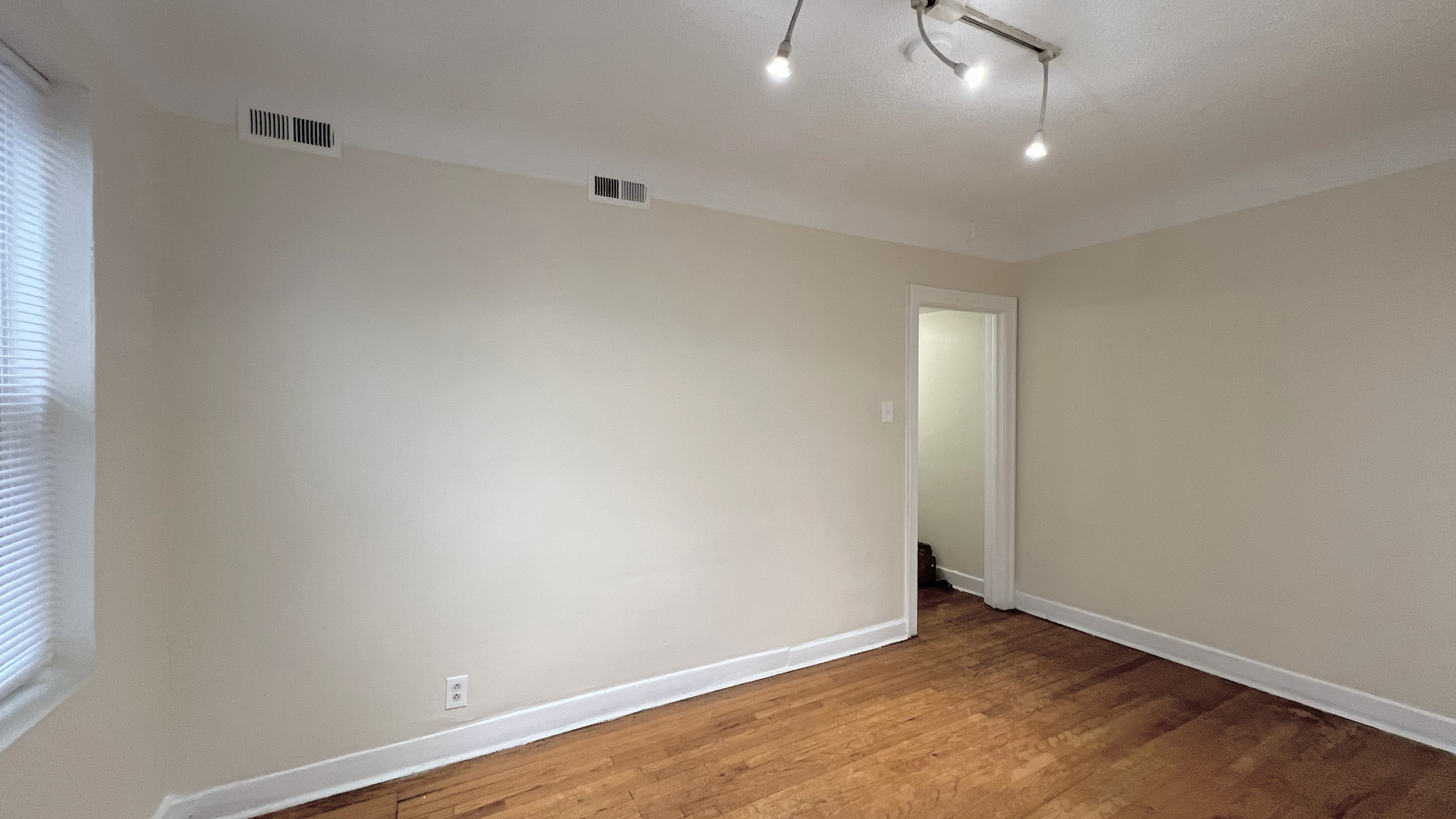 819 West 83rd Street, Unit 1N Chicago, IL 60620 - Photo 4 of 6 an empty room with a ceiling fan and wooden floor