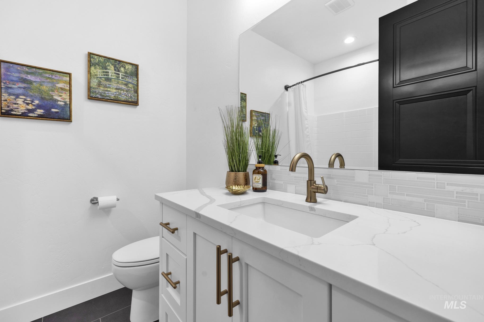 4280 Rim Vista Road Filer, ID 83328 - Photo 35 of 50 White vanity with integrated sink, quartz countertop, and a bronze-finish faucet