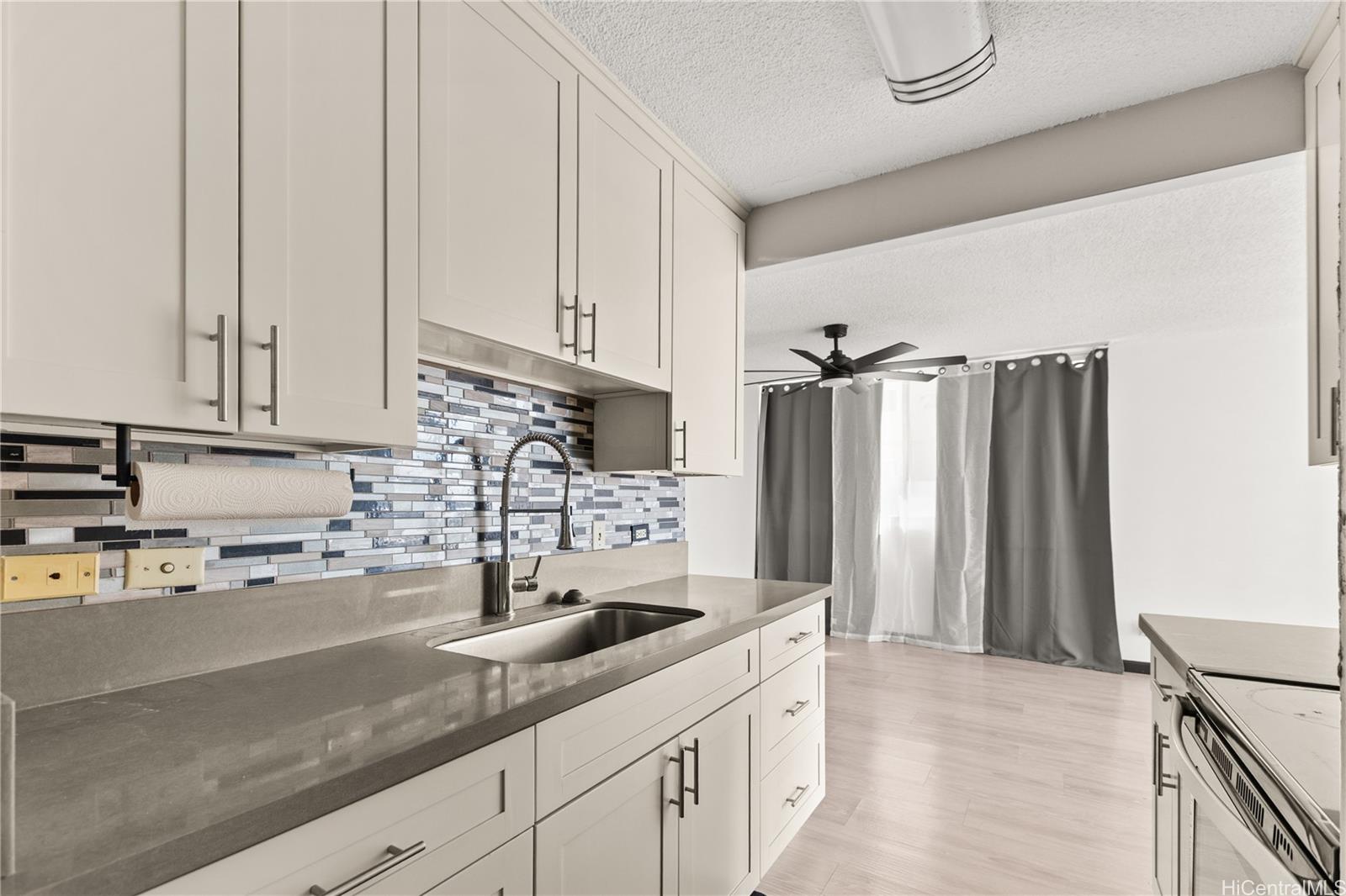 1069 Spencer Street, Unit 101 Honolulu, HI 96822 - Photo 1 of 19 a kitchen with stainless steel appliances granite countertop a sink a refrigerator and a white cabinets