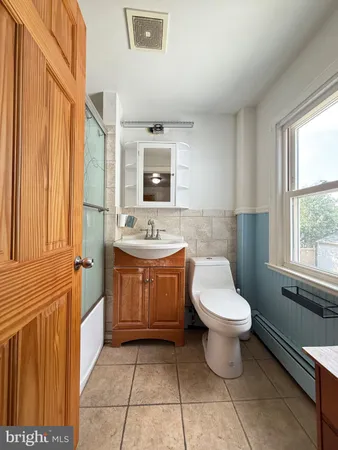 a bathroom with a sink toilet and window