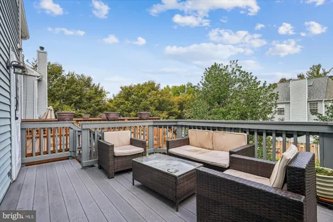 a view of a balcony with wooden floor and outdoor seating